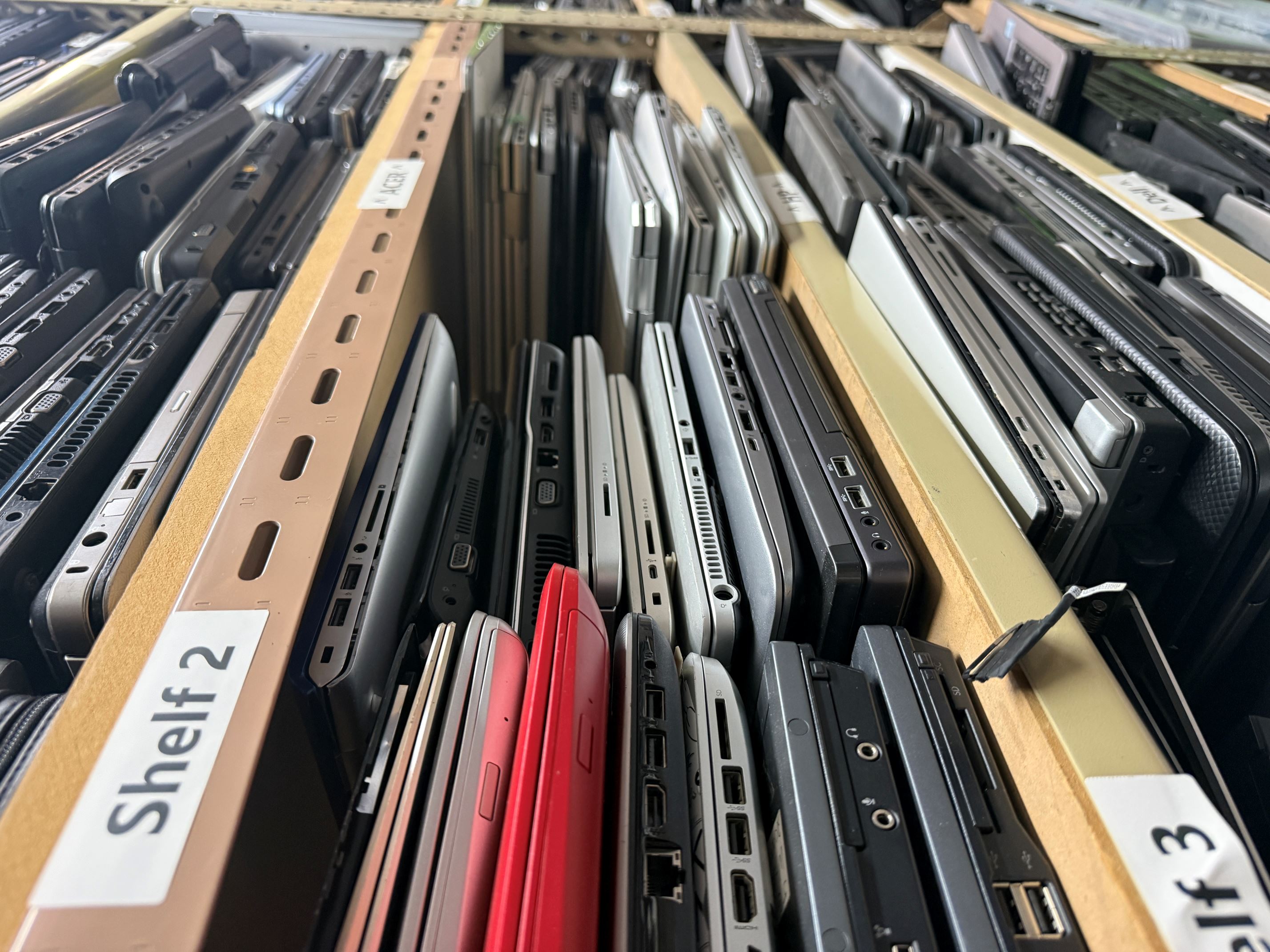 Shelves of used laptops ready for recycling at PC Galore
